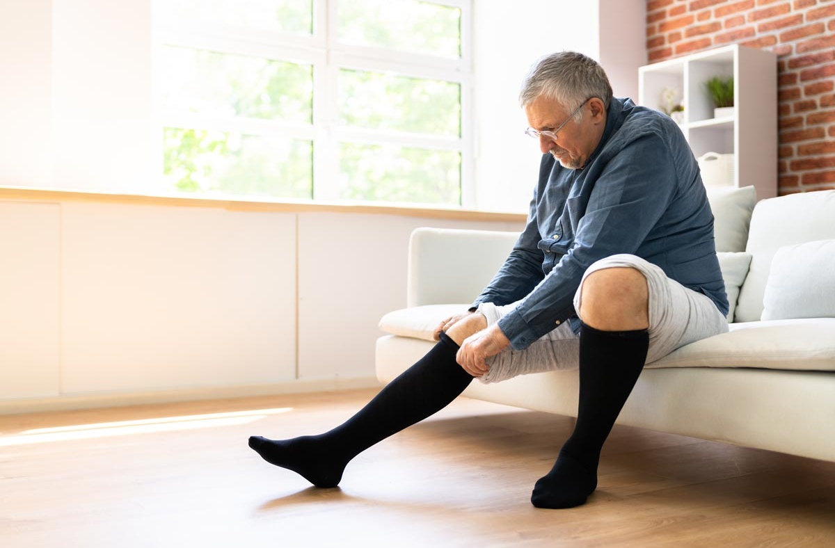 Man putting on compression stockings