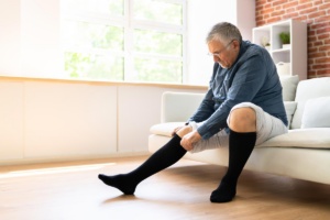 Man putting on compression stockings