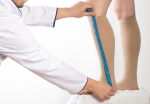 Doctor measuring for compression stocking fit