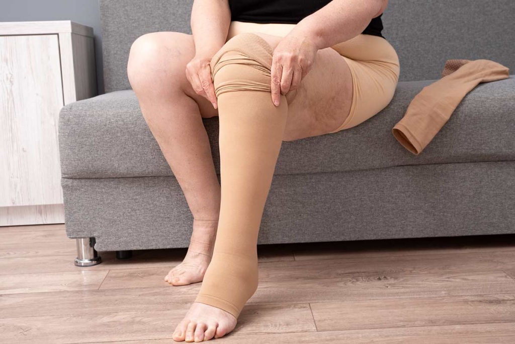 woman putting on compression stockings